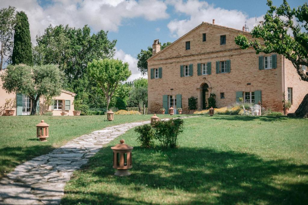 ein Steinweg vor einem großen Haus in der Unterkunft La Monteduccia in Ostra Vetere