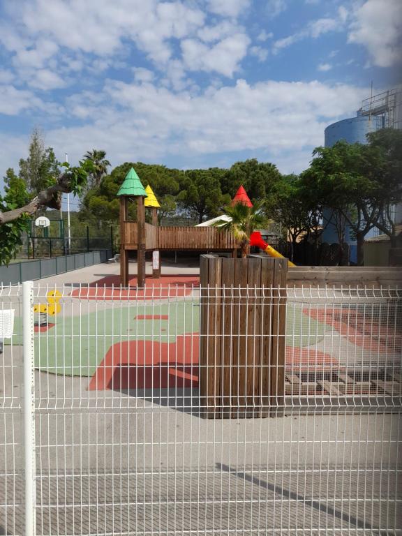 a playground behind a fence with a play park at Mobil Home 6 couchages in Vic-la-Gardiole