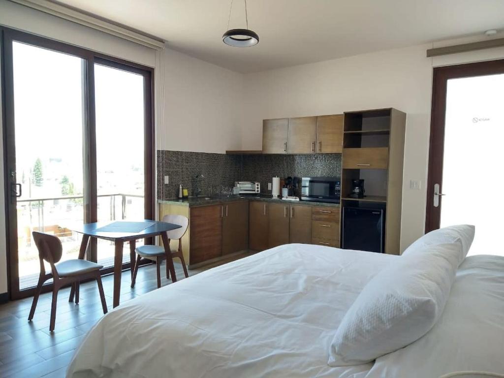 a bedroom with a bed and a table and a kitchen at Suite Loft Amplio Nuevo Salida a CDMX 204A in Querétaro