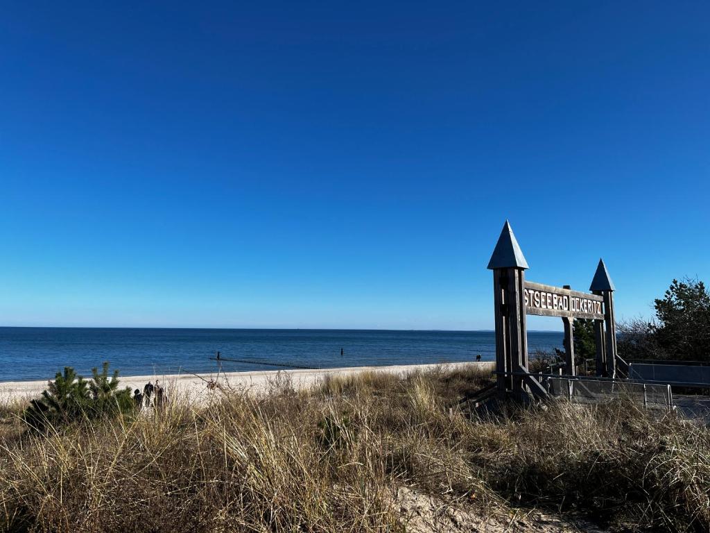 um sinal numa praia com o oceano ao fundo em Haus 1 em Ückeritz