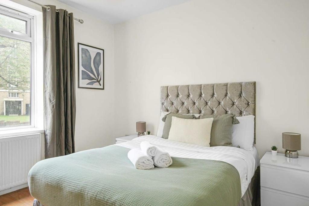 a bedroom with a large bed with towels on it at Paddington with Balcony - CityApartmentStay in London