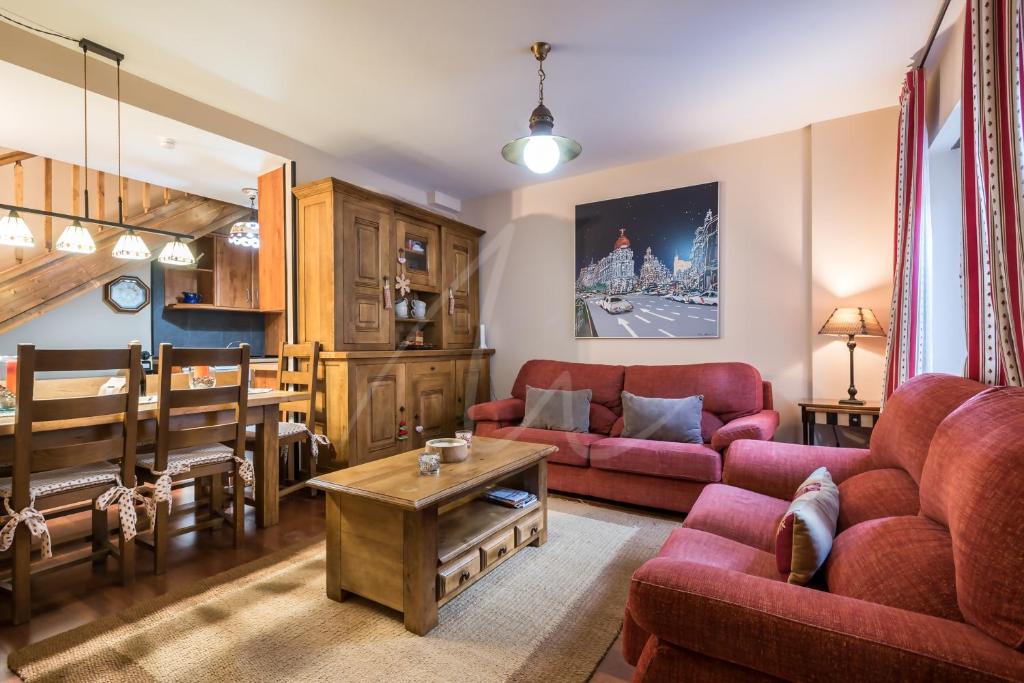 a living room with red couches and a table at Casa Garona by SeaMount Rentals in Bossost