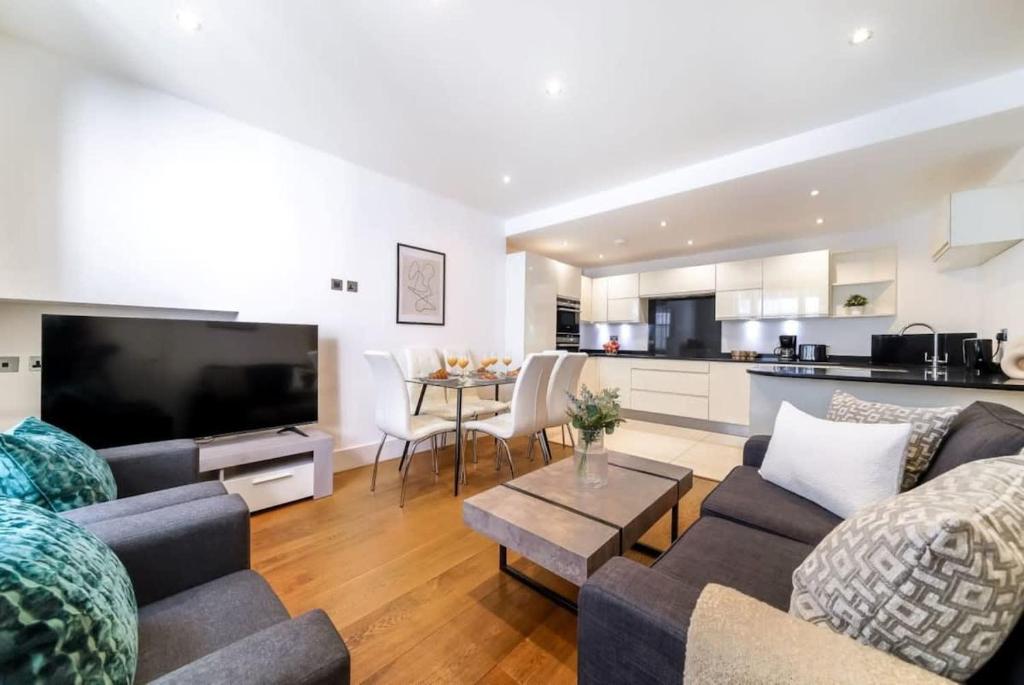 uma sala de estar com dois sofás e uma cozinha em Notting Hill & Hyde Park - CityApartmentStay em Londres