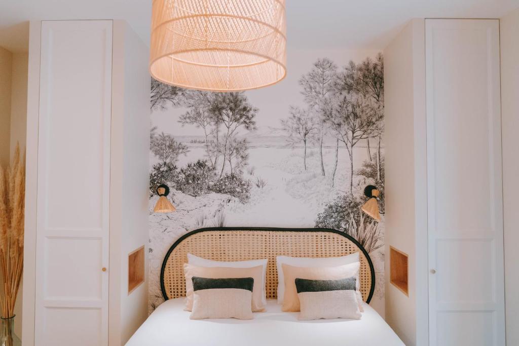 a bedroom with a bed and a chandelier at Apparts' Rennes BnB Duhamel- Centre Gare in Rennes