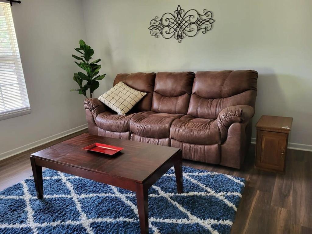 un sofá de cuero marrón en una sala de estar con mesa de centro en Welcome Home to this 2 bedroom 1 bath apartment near TTU, en Cookeville