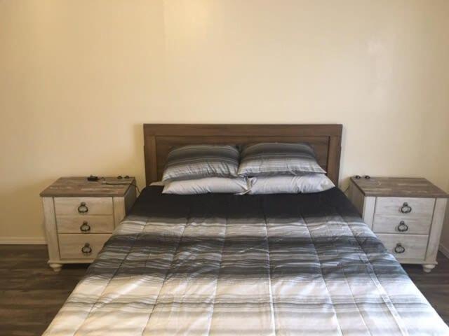 um quarto com uma cama e duas mesas de cabeceira em Downstairs One Bedroom Close To Fort Sill! em Lawton