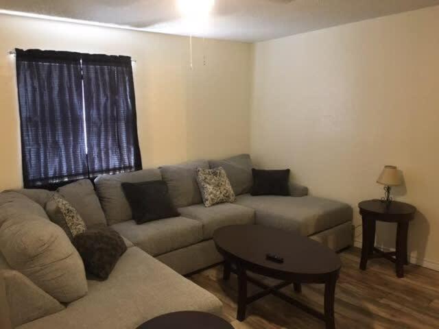uma sala de estar com um sofá e uma mesa em Close to Fort Sill Upstairs 1 bedroom apartment em Lawton