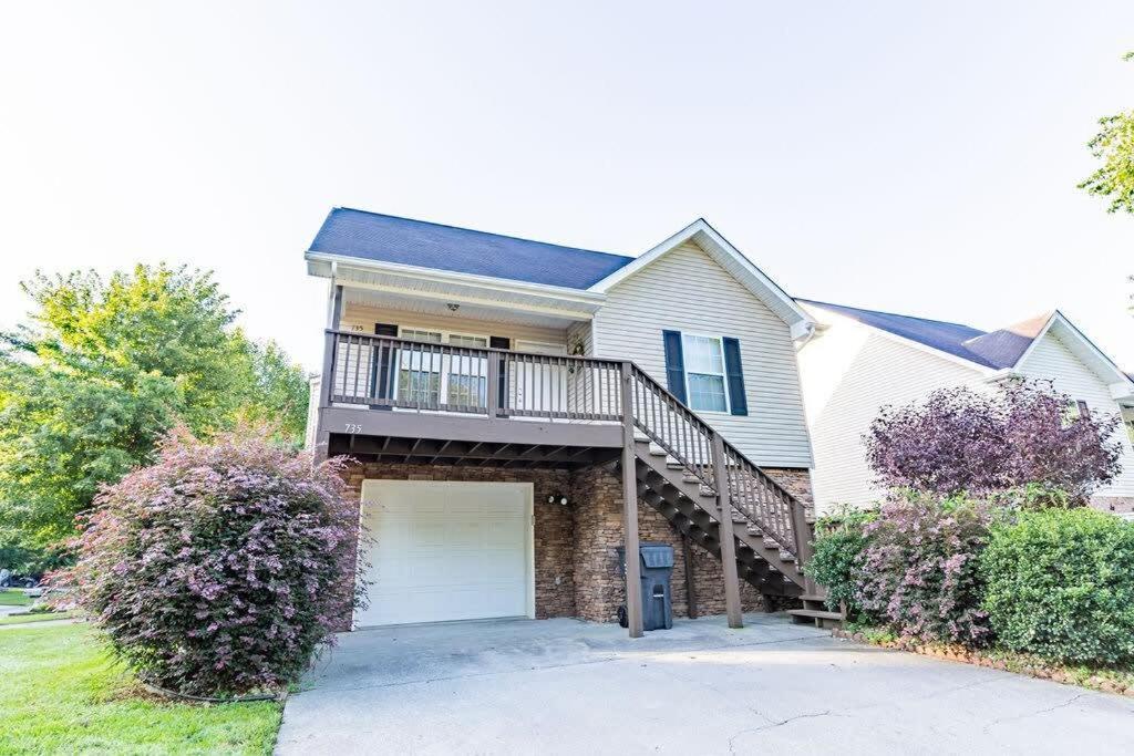 a white house with a staircase and a garage at Cozy, comfortable Pigeon Forge home close to all attractions and beautiful river in Pigeon Forge