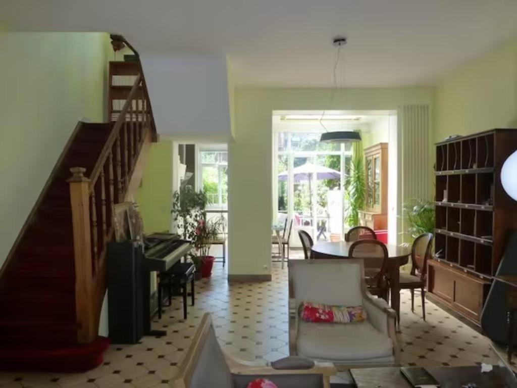 - un salon avec un escalier, une table et des chaises dans l'établissement Maison confortable et jardin à Lille, à Lille