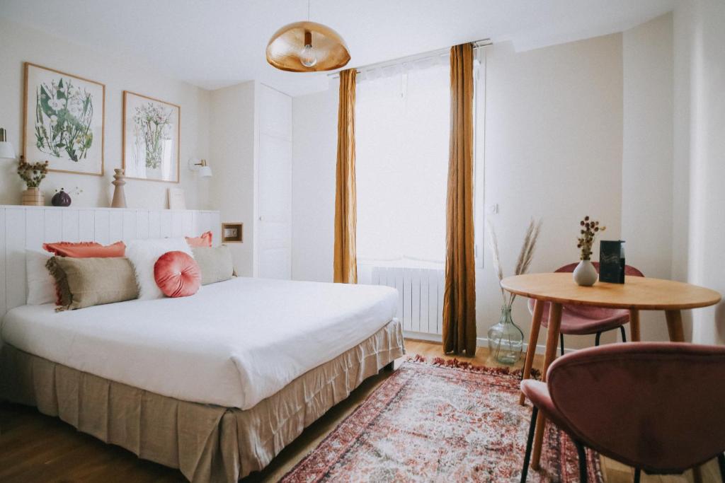 1 dormitorio con cama, mesa y ventana en Apparts' Rennes BnB Solferino -Centre Gare en Rennes