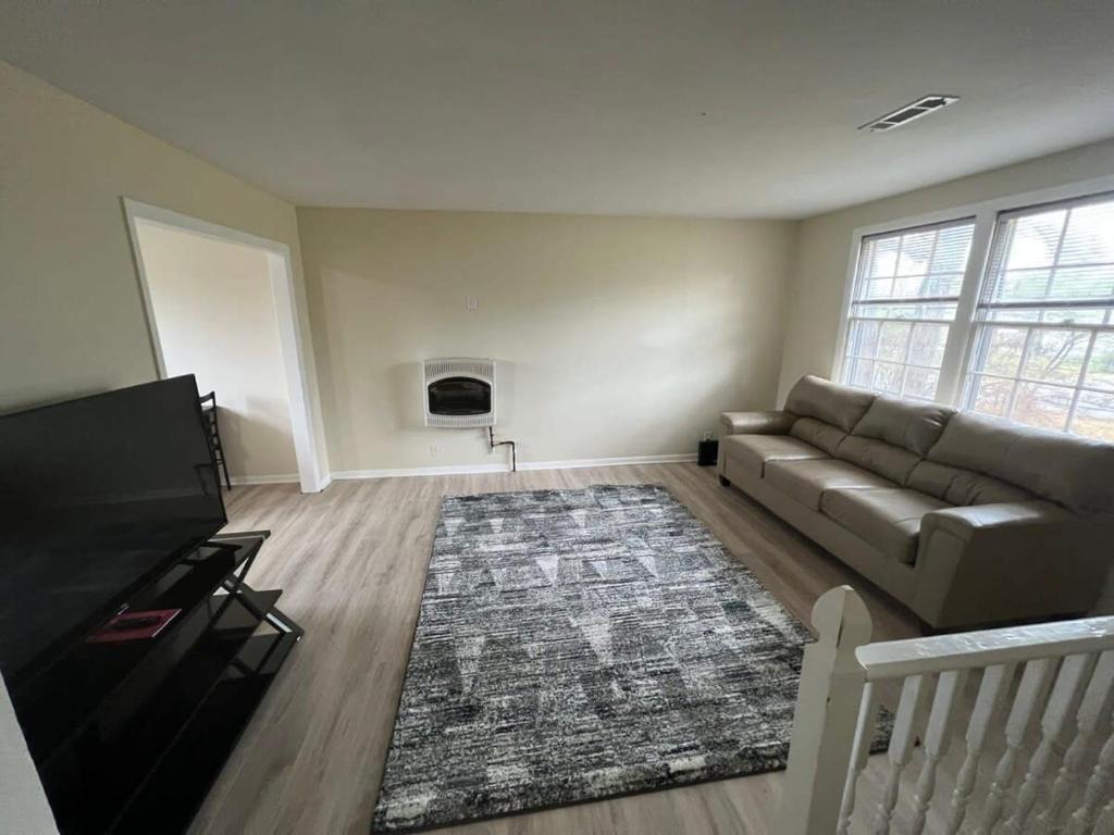 a living room with a couch and a rug at A great place for you to come rest your head in Gallatin