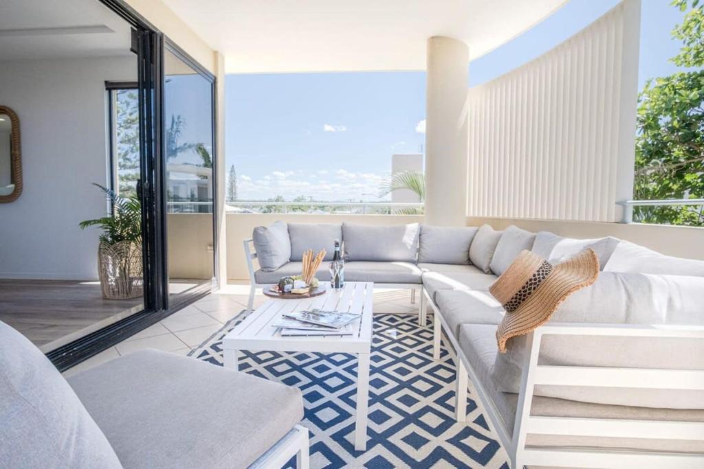a living room with a white couch and a table at Live like a local In The Heart of Moffat Beach in Caloundra