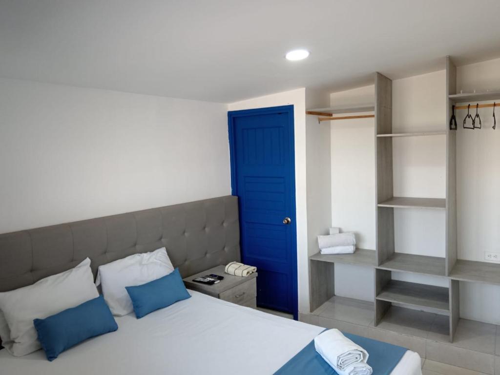 a bedroom with a blue door and a bed with blue pillows at Cozzy studio inside walled city & historic center in Cartagena de Indias
