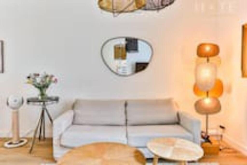 ein Wohnzimmer mit einem Sofa und einem Tisch in der Unterkunft Maison au pied de la plage in Les Sables-dʼOlonne