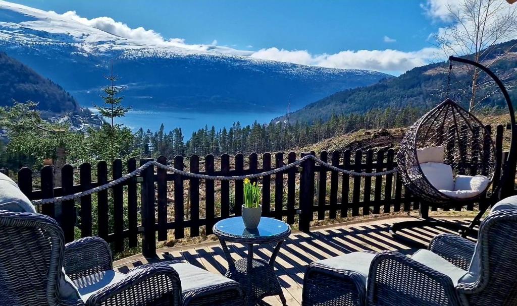 d'une terrasse avec des chaises et une table offrant une vue sur les montagnes. dans l'établissement Mountain View Apartment, à Stryn