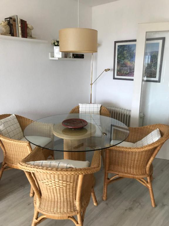 comedor con mesa de cristal y sillas de mimbre en Narciso views, en Vilassar de Mar