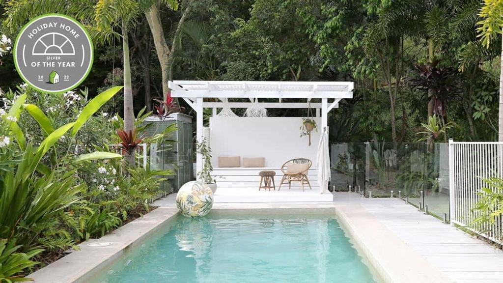 uma piscina com um gazebo, uma mesa e uma cadeira em Buderim Rainforest Retreat - 10 mins to Mooloolaba em Buderim