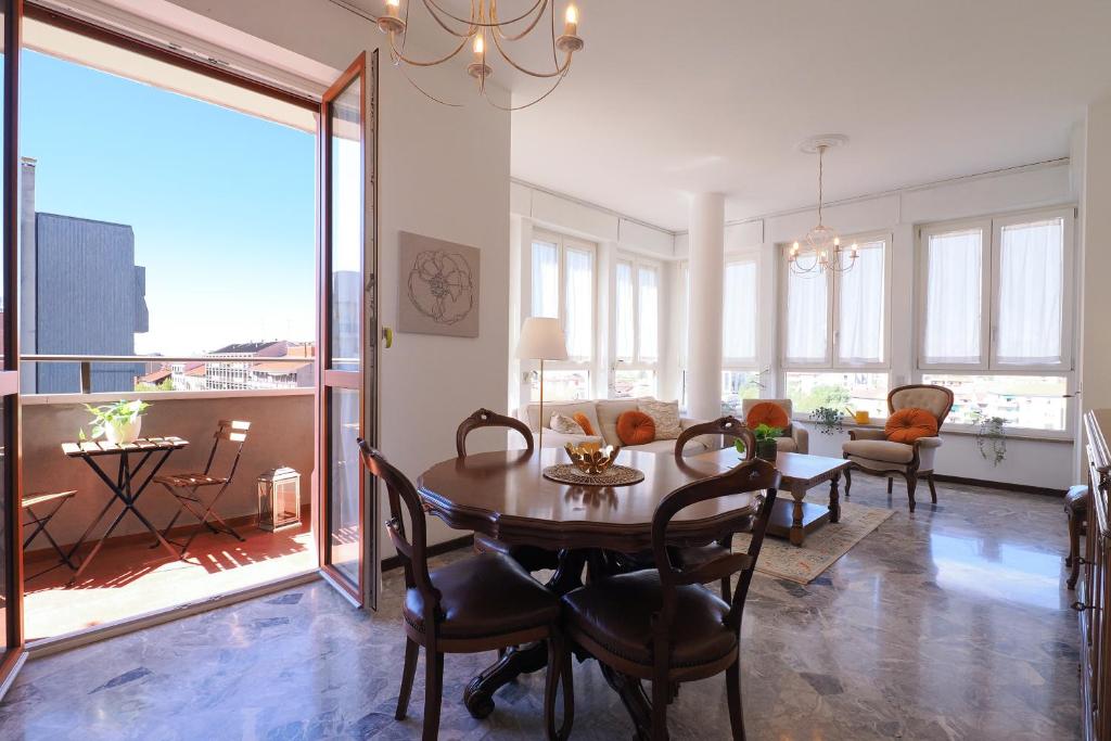 a dining room and living room with a table and chairs at Primopiano - Marelli in Sesto San Giovanni