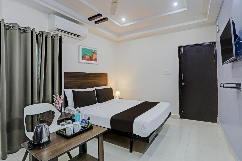 a bedroom with a bed and a desk with a chair at Hotel White Ridge Near Kondapur in Kondapur