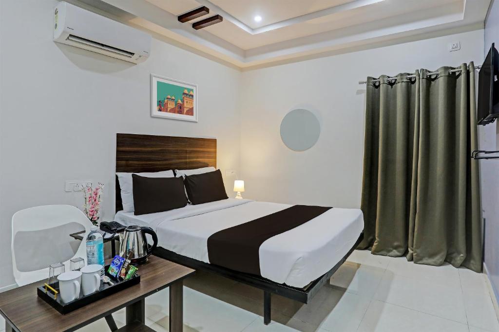 a bedroom with a bed and a desk and a bed sidx sidx sidx at Hotel White Ridge Near Kondapur in Kondapur