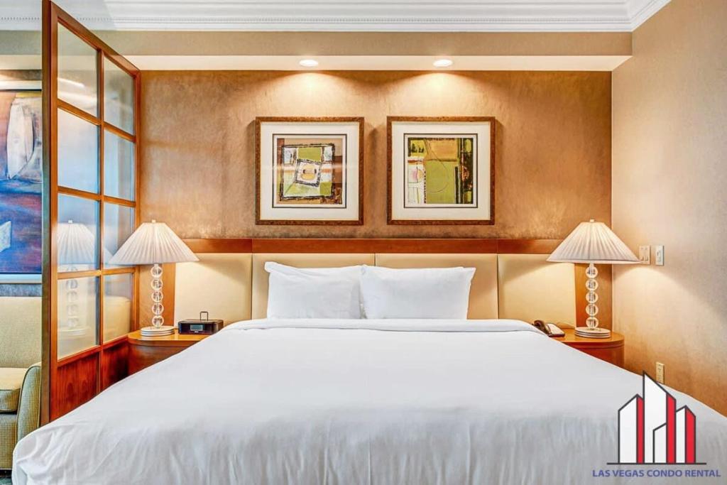 een slaapkamer met een groot wit bed en 2 lampen bij MGM Signature-12-718 Accessible Studio in Las Vegas