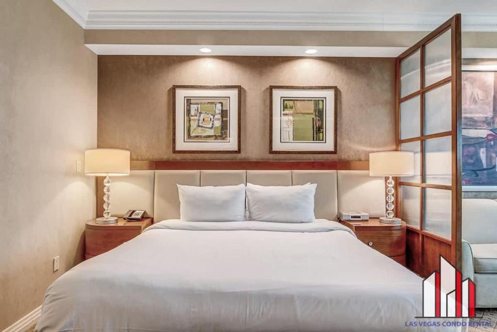 a bedroom with a large white bed and two lamps at MGM Signature-21-609 Strip View Jacuzzi Studio in Las Vegas