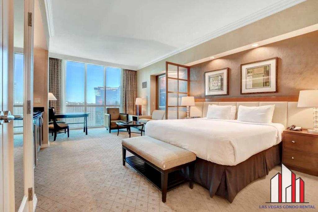ein Hotelzimmer mit einem großen Bett und einem Schreibtisch in der Unterkunft MGM Signature-36-603 Strip View Jacuzzi Studio in Las Vegas