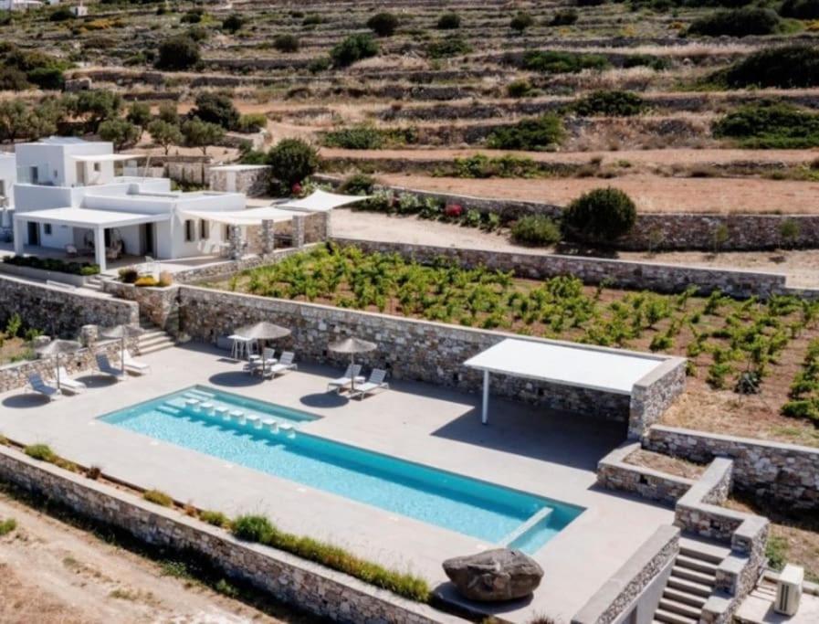 an aerial view of a villa with a swimming pool at Stunning new villa with great pool area, magnificent panoramic sea view - Paros in Angairiá