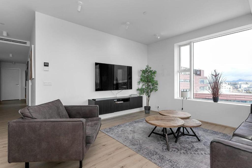 sala de estar con sofá, mesa y TV en Spacious Luxury 3BR Apartment with 2 bathrooms 1003 en Reikiavik