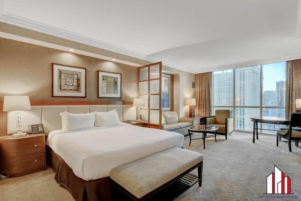 a hotel room with a large bed and a desk at MGM Signature-20-609 Strip View Jacuzzi Studio in Las Vegas