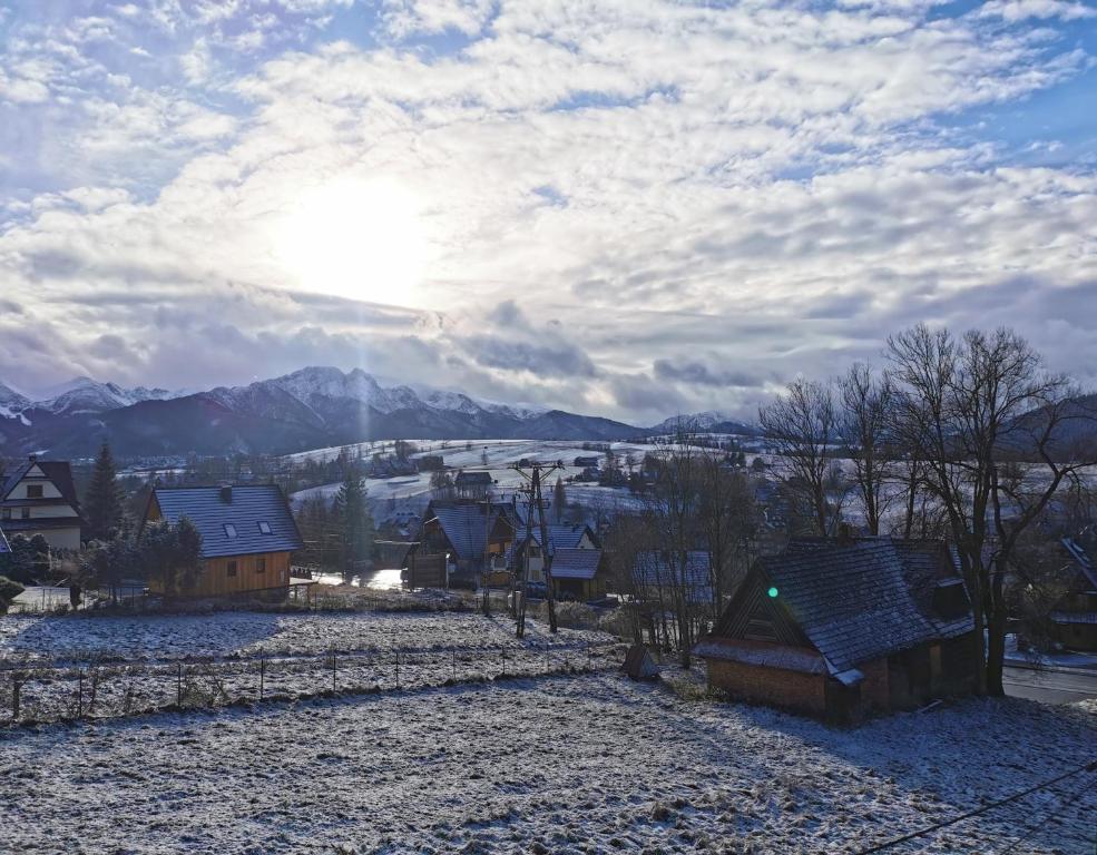 Blick auf ein Dorf im Schnee mit Bergen in der Unterkunft Czarny Jeleń in Zakopane