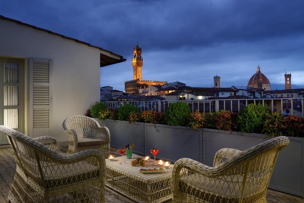 佛羅倫斯的住宿－Hotel Balestri - WTB Hotels，天井配有两把椅子和一张带蜡烛的桌子。
