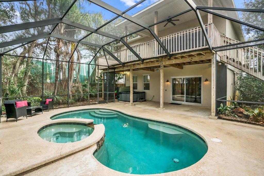 uma piscina interior numa casa com um pátio em Pool + Hot Tub, Dock, Fishing, Near Beach! em Saint Augustine
