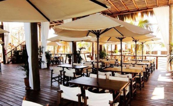 a restaurant with tables and chairs with umbrellas at HOTEL RUSTICA VICHAYITO in Vichayito