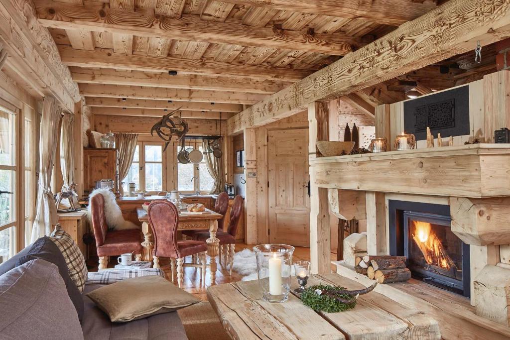 a living room with a fireplace and a table at GÓRSKA OSADA Beautiful Chalets Zakopane in Zakopane