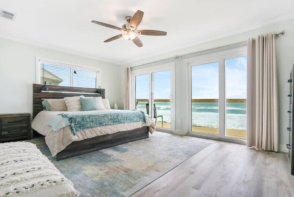 Schlafzimmer mit einem Bett und einem Deckenventilator in der Unterkunft Spectacular Oceanfront! Blissful Balconies + BBQ in St. Augustine