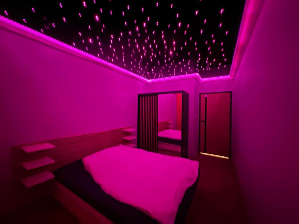 ein lila Schlafzimmer mit einem Bett und einem Spiegel in der Unterkunft Blue Sky 39 in Danzig