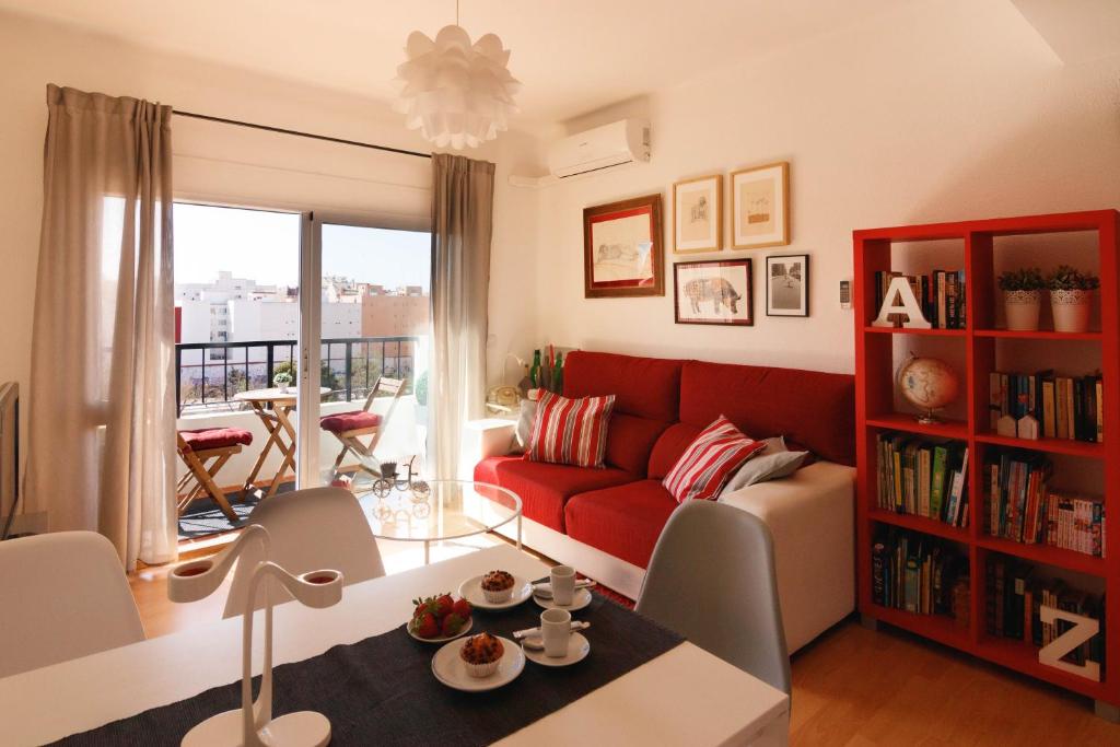 a living room with a red couch and a table at LUMINOSO. COMODO. ACOGEDOR. WIFI. Junto a AVE in Valencia