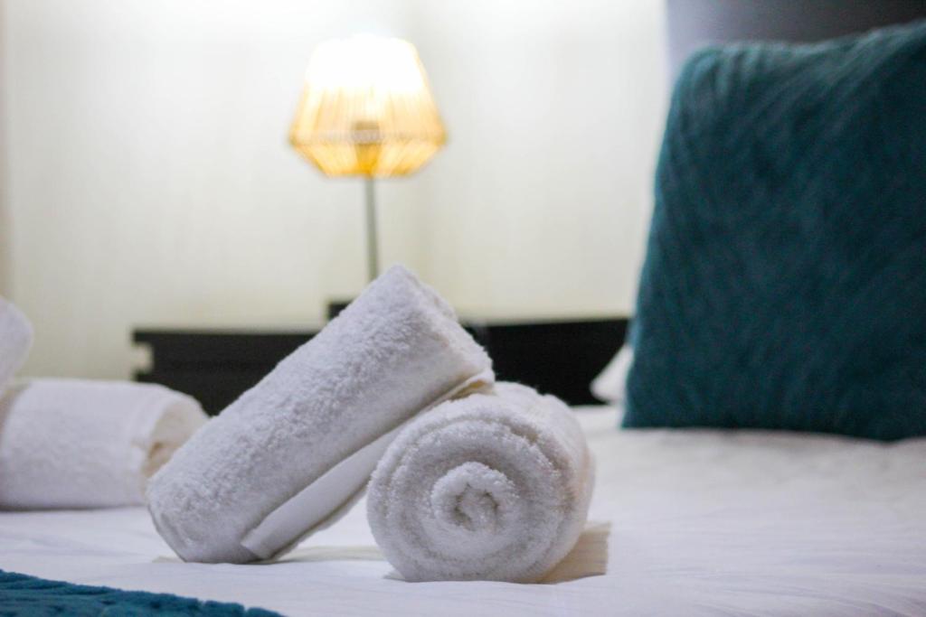 Una pila de toallas encima de una cama en Vieira Rooms Natural Pools, en Ponta Delgada