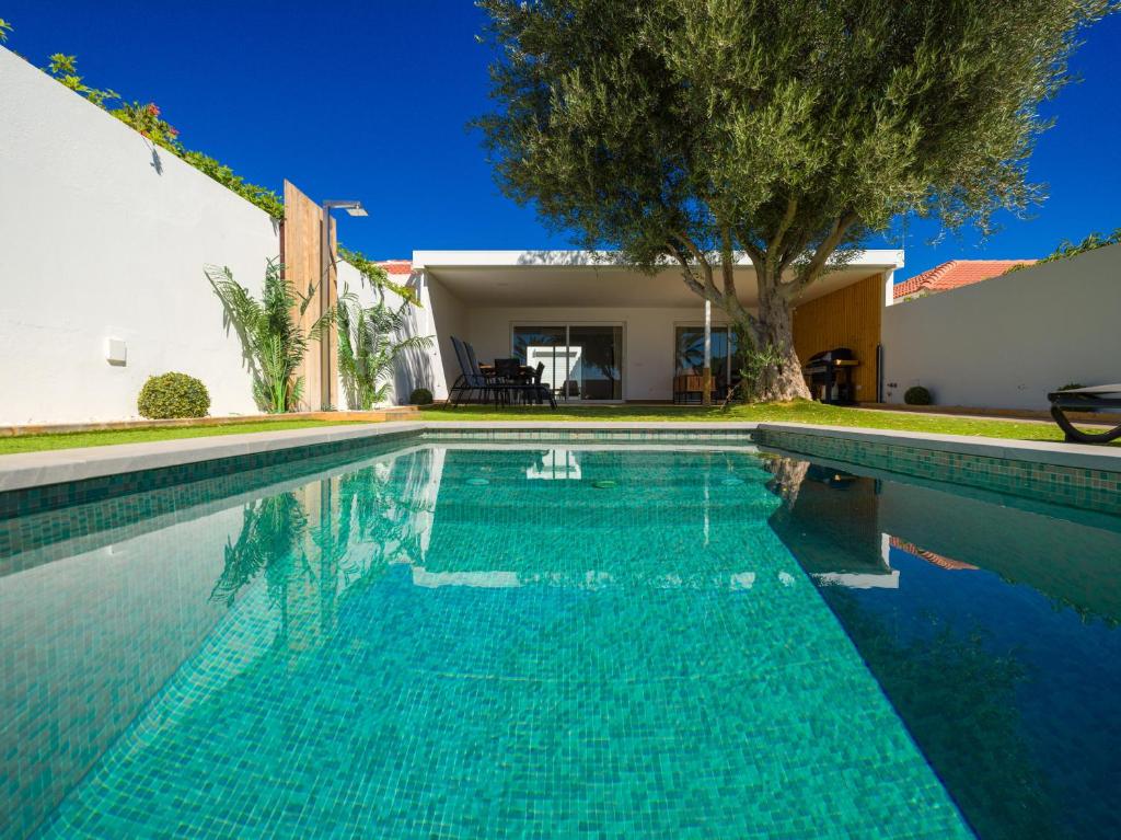 a swimming pool in front of a house at Pasito Blanco Villas in Pasito Blanco