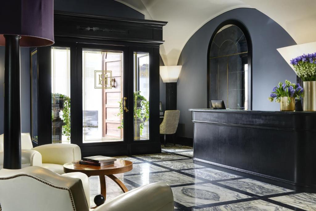 a living room with a table and chairs at Hotel Balestri - WTB Hotels in Florence