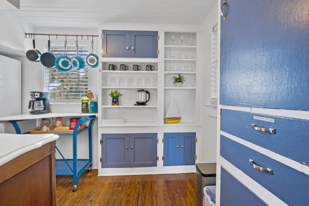 une cuisine avec des armoires bleues et des comptoirs blancs dans l'établissement Marvelous Mermaid Bungalow, Dog-Friendly Upstairs Apt in Prime Vilano Beach, à Saint Augustine