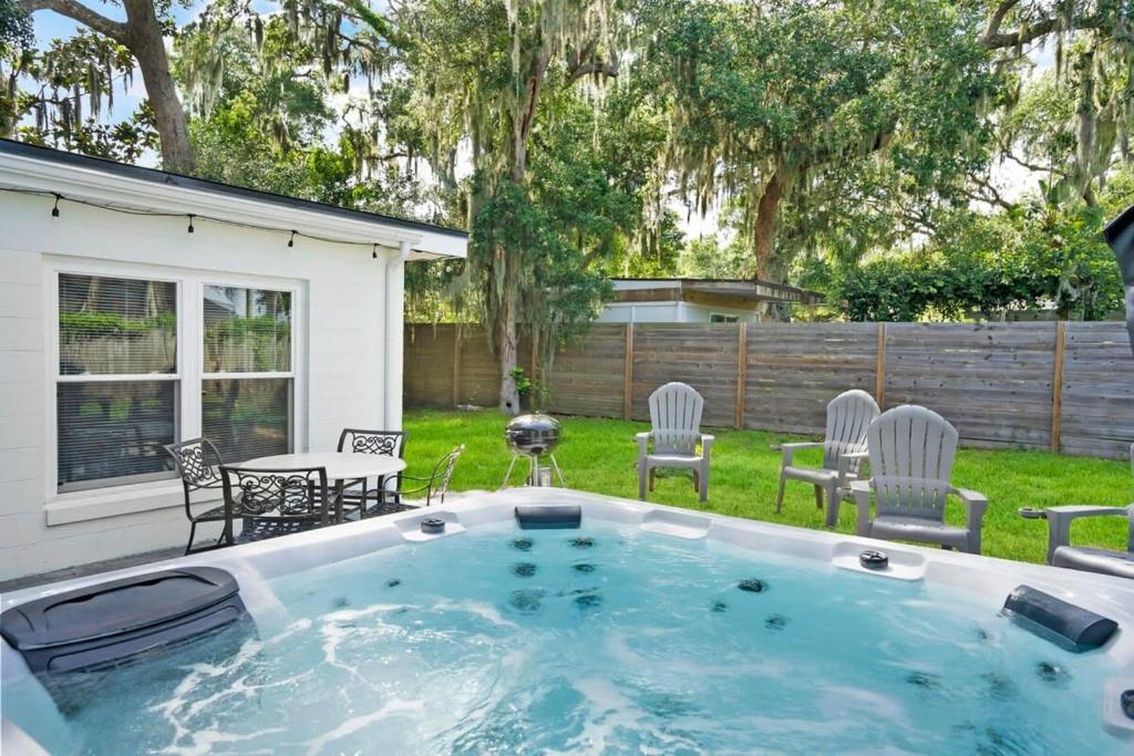 una bañera de hidromasaje en un patio con sillas y mesa en Rave Reviews for Waterway Views Spa Comfy Beds Bring Your Boat, en St. Augustine