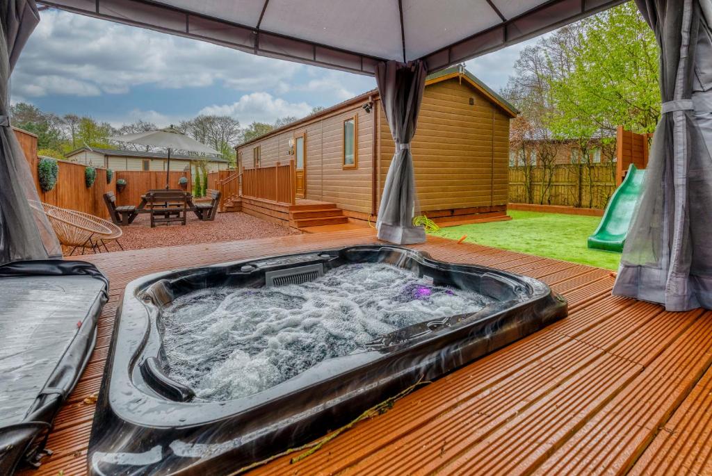 uma banheira de hidromassagem no deque de uma casa em Family Luxury York Cabin Retreat with hot tub em York