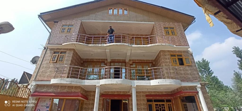 a man standing on the balcony of a building at Valley holidays in Srinagar