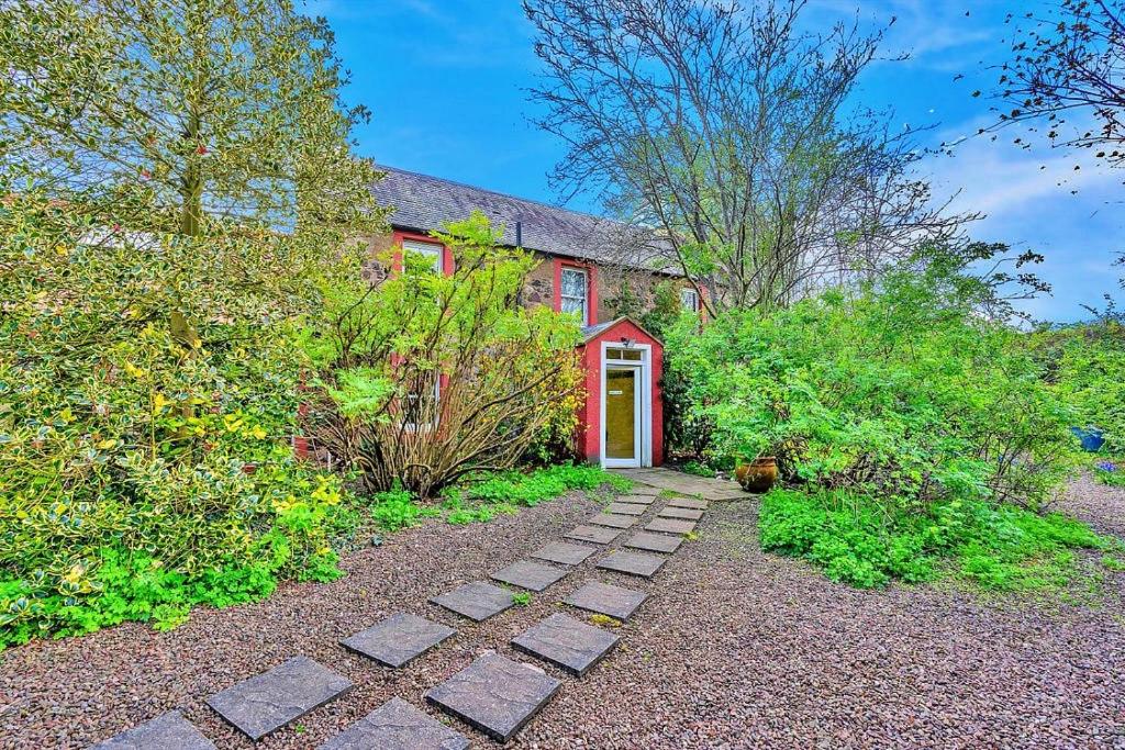 a red house with a red door and a walkway at Finest Retreats - The West Wing at The Mill House in East Linton