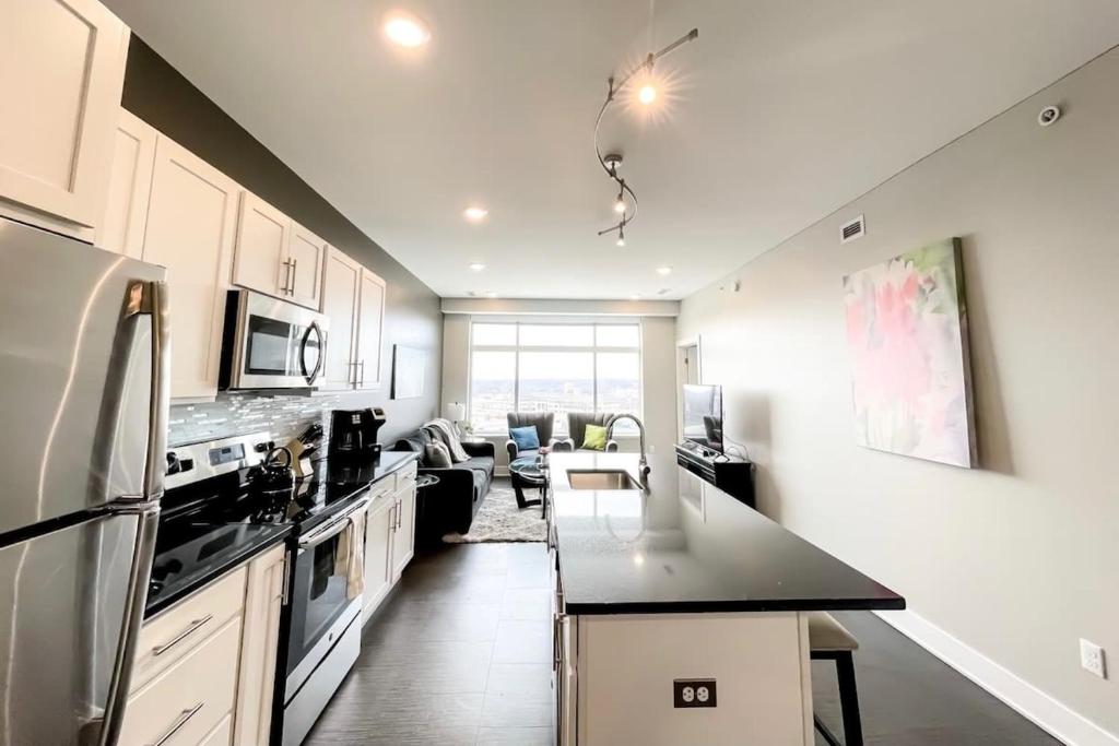 a kitchen with white cabinets and a black counter top at 2BR 2BA Top Floor DT GR Penthouse Parking &Gym in Grand Rapids