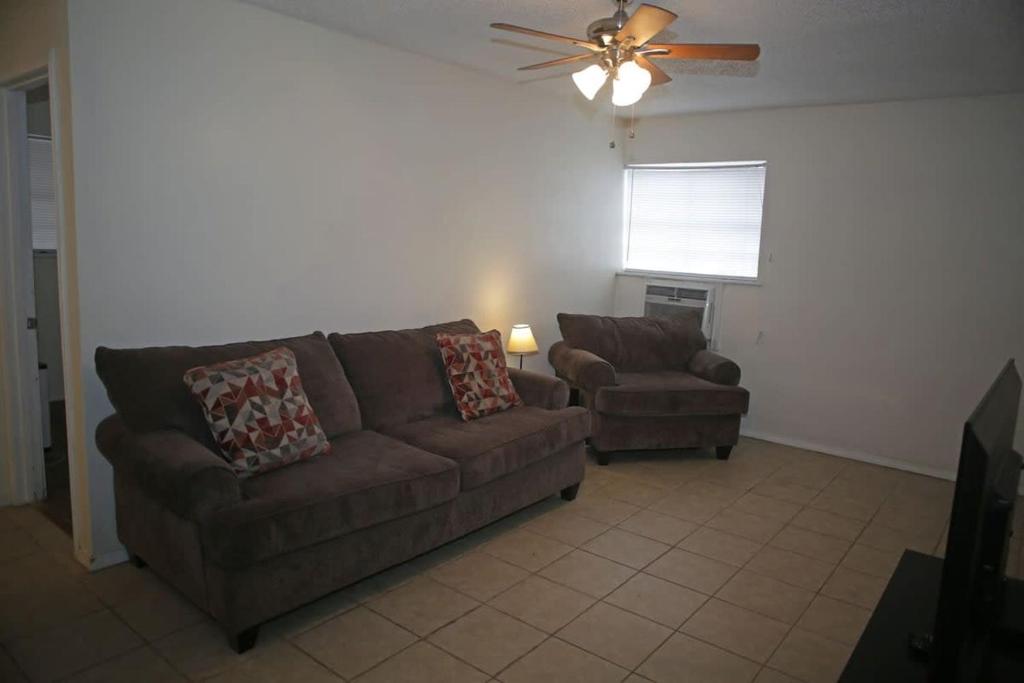 uma sala de estar com um sofá e uma cadeira e uma ventoinha de tecto em Apartment next to Fort Sill Entrance Gate em Lawton