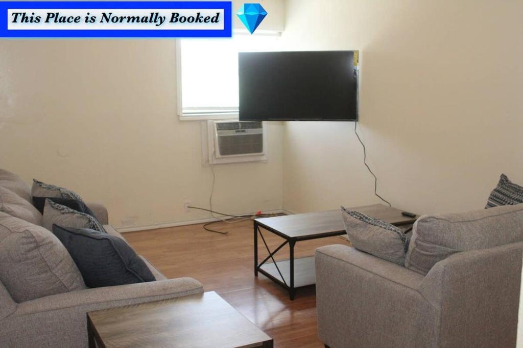 ein Wohnzimmer mit 2 Stühlen und einem Flachbild-TV in der Unterkunft 1 bedroom apartment within sight of Fort. Sill in Lawton