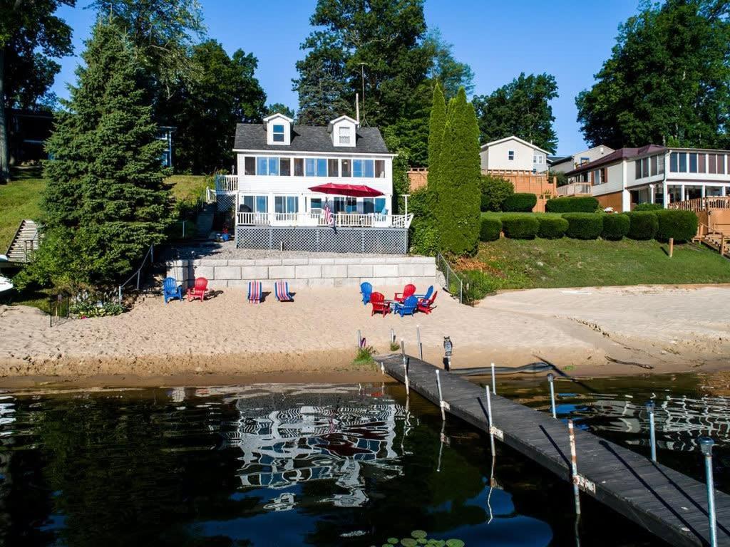 ein Haus mit einem Dock neben einem Wasserkörper in der Unterkunft Priscilla's Place on Big Pine Island Lake in Belding